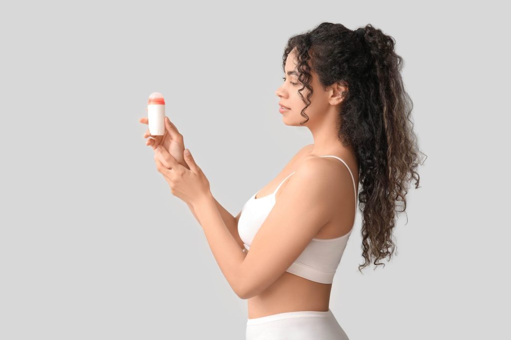 Hyperhidrosis - all you need to know & the best wat to combat it Photo - A woman holding up a stick of deodorant