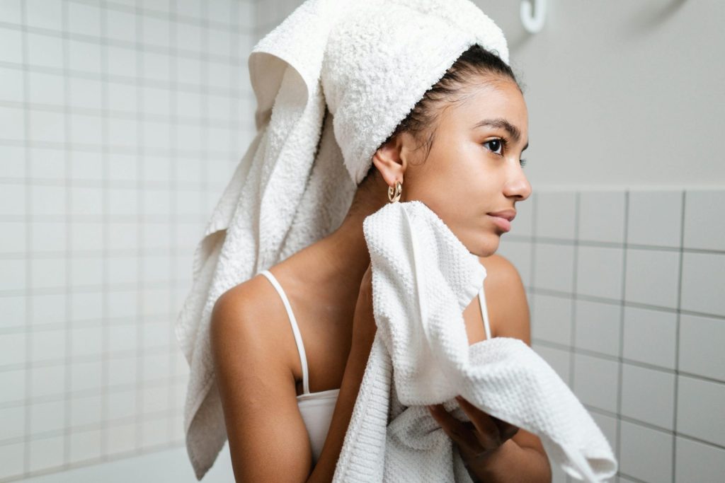 Introducing Polynucleotide Salmon Sperm: The no. 1 Skin Booster Changing Aesthetics Photo - A woman with clear skin free from wrinkles looking into the mirror