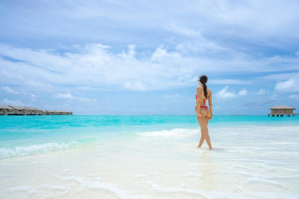 How Hip Dip Fillers Can Balance Your Shape Photo - A beautiful woman at a beach showing off her figure